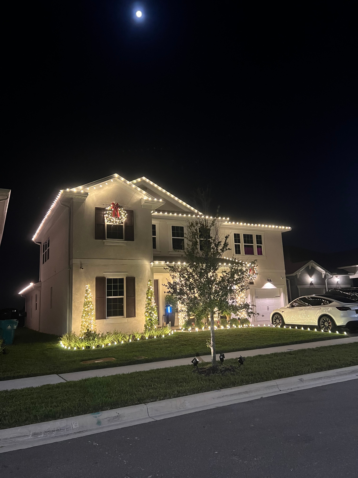 Two-story home with stunning roofline and landscape lighting installation